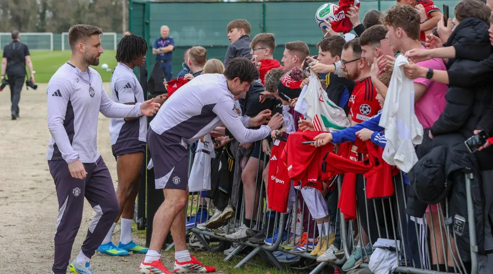 نجم يونايتد وإنجلترا يوقع على قمصان مجموعة من المشجعين والأطفال (أ.ف.ب)