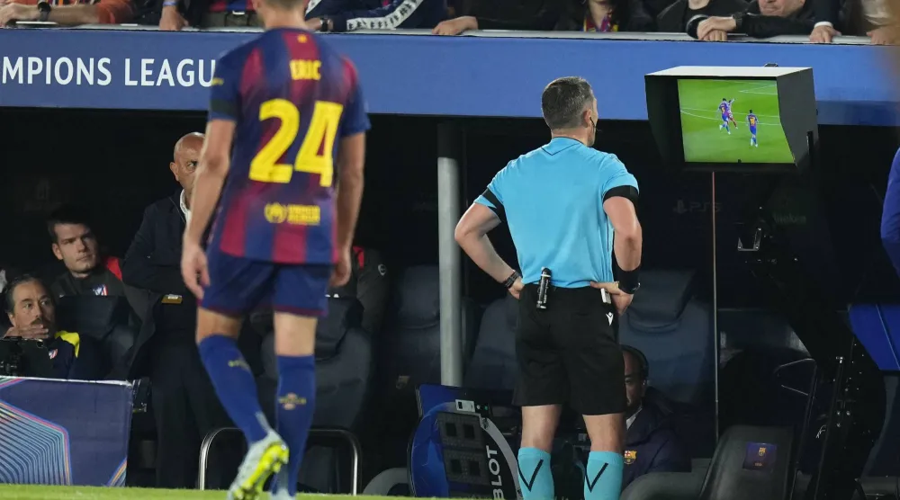 حكم مباراة برشلونة وأتلتيكو يراجع إحدى الحالات عبر تقنية الفار (إ.ب.أ)