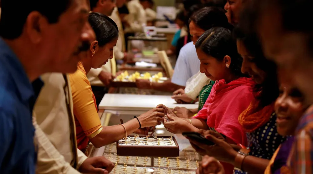 زبائن يتجمعون داخل صالة عرض للمجوهرات في متجر للذهب في كوتشي الهند (رويترز)