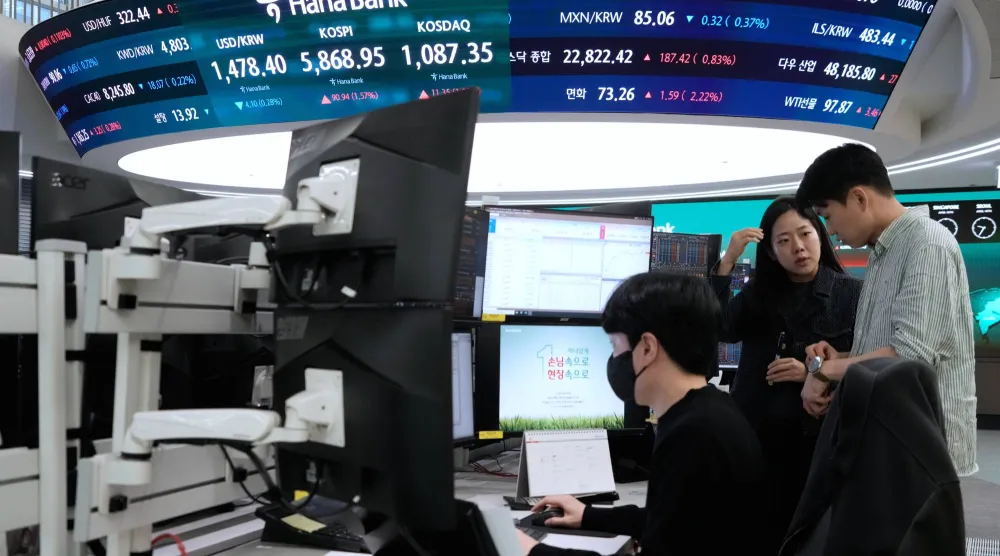 متداولون في سوق العملات يراقبون شاشة تعرض مؤشر «كوسبي» وسعر صرف الدولار/الوون في سيول (أ.ب)