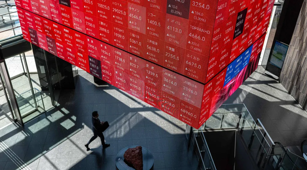 رجل يمر في مدخل بورصة طوكيو بالعاصمة اليابانية (أ.ف.ب)