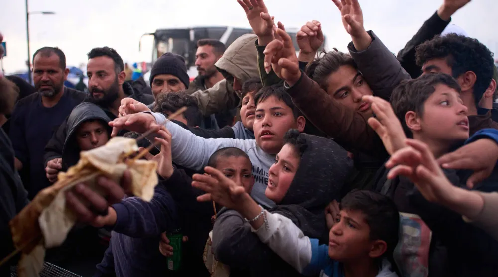 أطفال نازحون يتدافعون للحصول على الطعام المتبرع به بجانب الخيام التي يستخدمونها ملاجئ بعد فرارهم من القصف الإسرائيلي في جنوب لبنان... بيروت 9 أبريل 2026 (أ.ب)