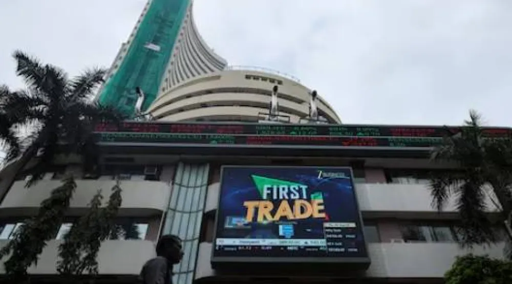 رجل يمشي بالقرب من شاشة خارج بورصة بومباي في مومباي (رويترز)