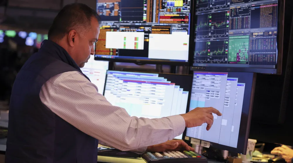 متداول يراقب شاشات تعرض مؤشرات الأسهم في بورصة نيويورك (إ.ب.أ)