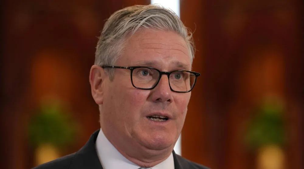 رئيس الوزراء البريطاني كير ستارمر يتحدث إلى وسائل الإعلام في مطار الدوحة الجمعة (أ.ف.ب)