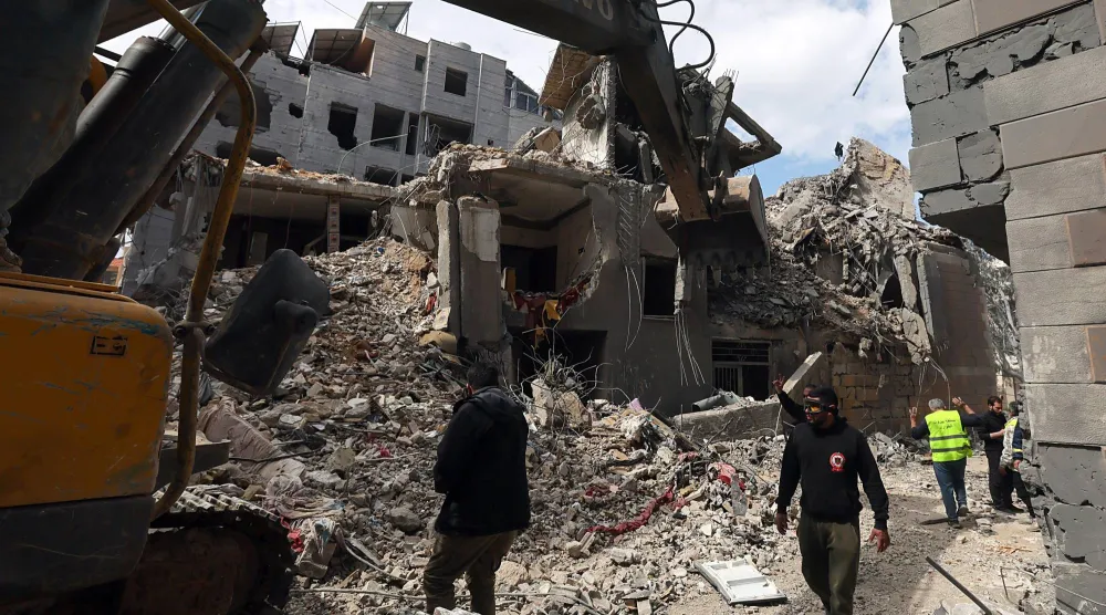 جرافة تزيل أنقاض مبنى دمرته غارات إسرائيلية على ضاحية بيروت الجنوبية (إ.ب.أ)