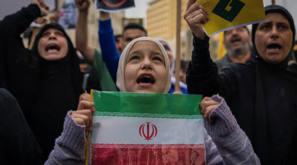 طفلة ترفع علم إيران في تحرك لـ«حزب الله» ضد رئيس الحكومة نواف سلام (رويترز)
