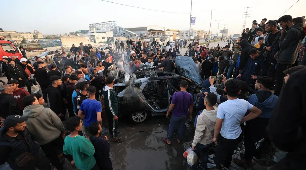 فلسطينيون يتفقدون مركبة استهدفتها غارة إسرائيلية في مخيم المغازي للاجئين الفلسطينيين وسط قطاع غزة (أ.ف.ب)