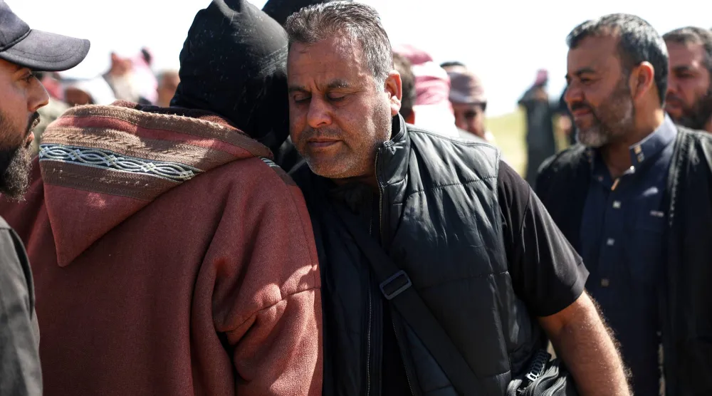 حمد الغالب يستقبل المشيعين خلال دفن زوجته وأطفاله في دير الزور (أ.ب)