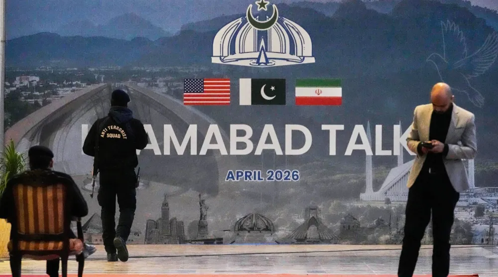 رجل أمن أمام لوحة لمحادثات إسلام آباد خارج مركز إعلامي أُقيم لتغطية المفاوضات بين الولايات المتحدة وإيران (ا.ب)