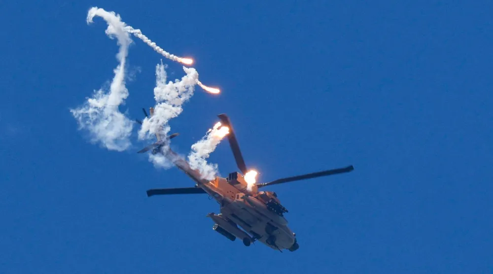 مروحية إسرائيلية من طراز «أباتشي» تطلق نيراناً مضيئة خلال تحليقها فوق لبنان (رويترز) 