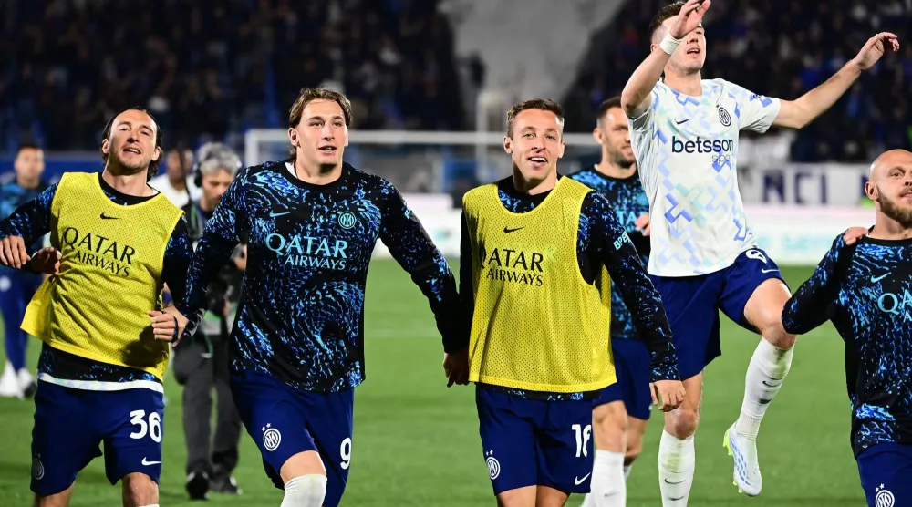 لاعبو إنتر ميلان يحتفلون مع جماهيرهم الزائرة بالفوز في كومو (أ.ف.ب)