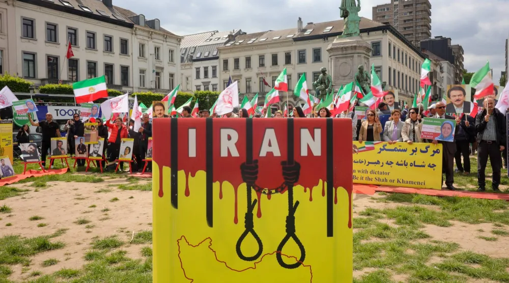 معارضون إيرانيون يرفعون لافتات مندِّدة بالإعدام في مظاهرة أمام البرلمان الأوروبي في بروكسل 24 مايو 2023 (إ.ب.أ)