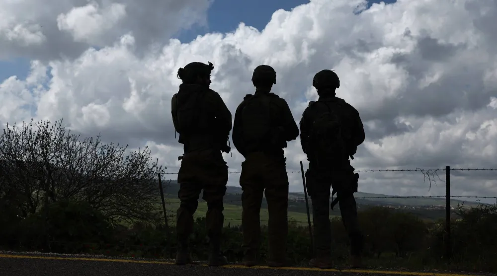 جنود إسرائيليون يتمركزون عند الحدود مع بلدة بنت جبيل في جنوب لبنان (إ.ب.أ)