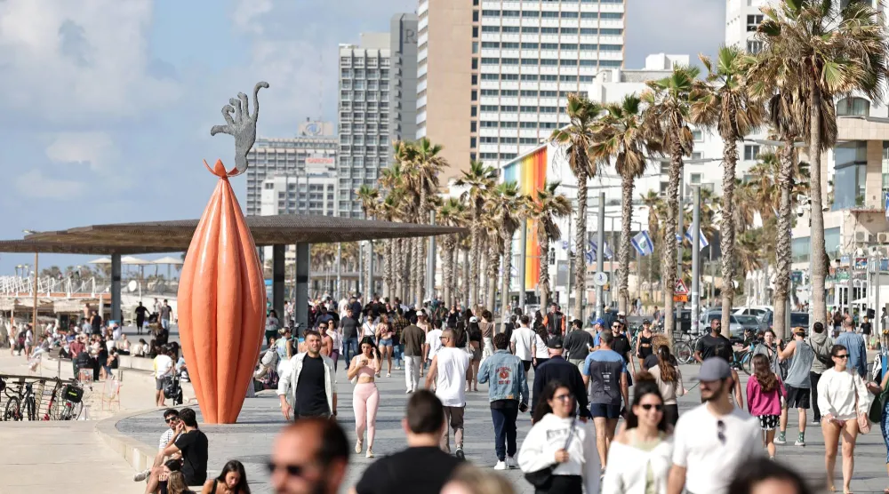 أشخاص يسيرون على طول ممشى بالقرب من الشاطئ في تل أبيب بإسرائيل 8 أبريل 2026 (إ.ب.أ)