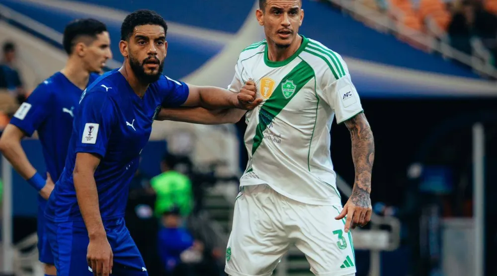 البرازيلي روجر إيبانيز مدافع فريق الأهلي في صراع مع لاعب من الدحيل (النادي الأهلي)