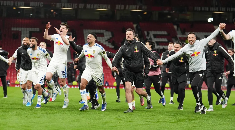 احتفالية لاعبي ليدز يونايتد أمام جماهيرهم الزائرة في أولد ترافورد (د.ب.أ)