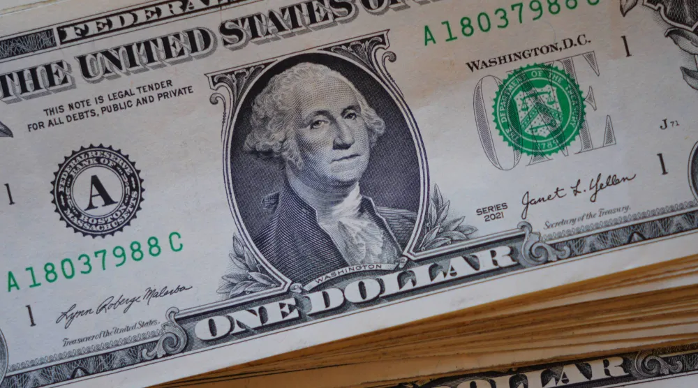 صورة لجورج واشنطن معروضة على كومة من الأوراق النقدية الأميركية من فئة الدولار الواحد في دالاس (أ.ب)