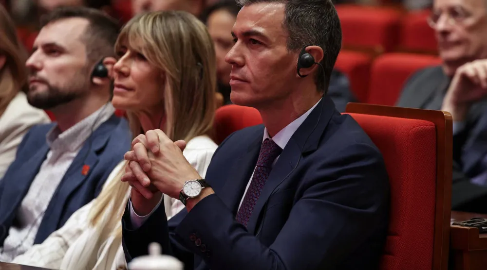 رئيس الوزراء الإسباني بيدرو سانشيز وزوجته بيغونيا غوميز يحضران خطاباً في جامعة تسينغهوا في بكين أمس (رويترز)