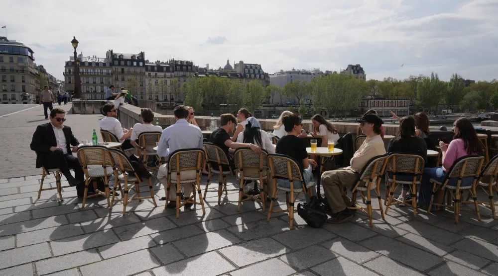People sit at a bistro, enjoying the sun in Paris, Thursday, April 9, 2026.(AP Photo/Michel Euler)