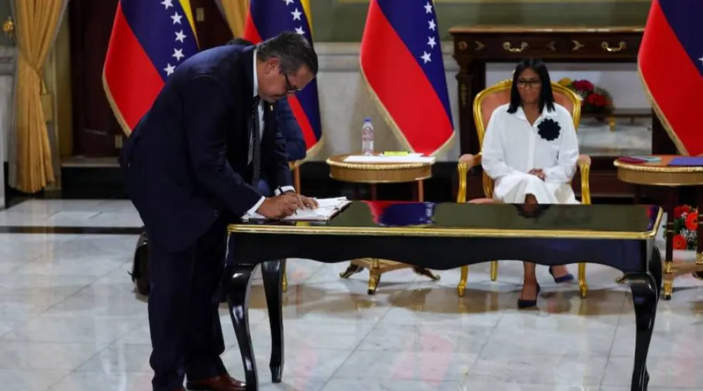 الرئيسة المؤقتة لفنزويلا ديلسي رودريغيز تتابع في حين يوقع رئيس «شيفرون» في فنزويلا على اتفاقية نفطية مع شركة النفط الحكومية الفنزويلية «PDVSA» في كاراكاس 13 أبريل 2026 (رويترز)