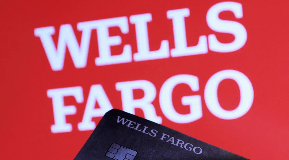 نموذج لبطاقة ائتمان تابعة لـ«ويلز فارغو» أمام شعار البنك (رويترز)