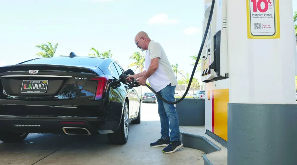 رجل يملأ سيارته بالوقود داخل محطة بنزين في ميامي (أ.ف.ب)