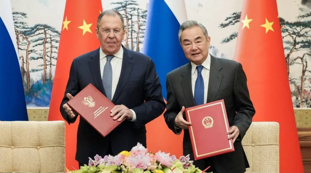 وزيرا خارجية الصين وانغ يي وروسيا سيرغي لافروف بعد توقيعهما على اتفاقية بين البلدين في بكين الثلاثاء (رويترز)