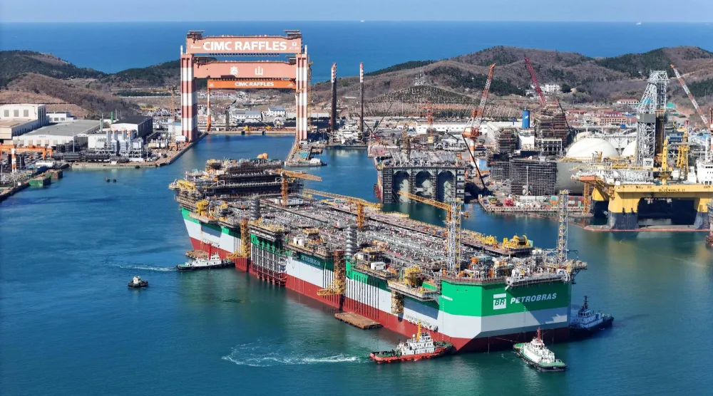 سفينة إنتاج وتخزين وتفريغ عائمة وهي تُسحب من حوض بناء السفن بواسطة قاطرات في يانتاي بمقاطعة شاندونغ شرق الصين (أ.ف.ب)