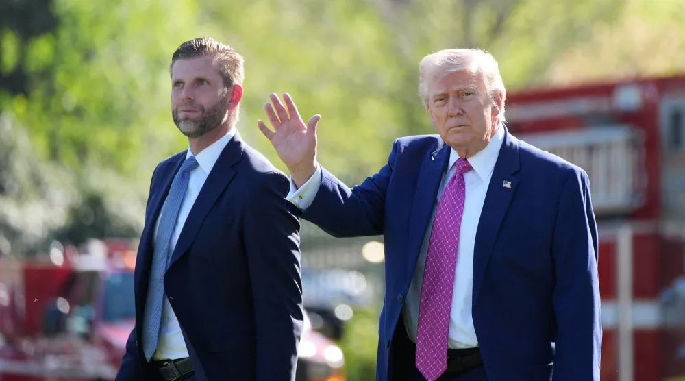 الرئيس الأميركي دونالد ترمب برفقة ابنه إريك يسيران قبل الصعود على متن طائرة في الحديقة الجنوبية للبيت الأبيض (أ.ب)