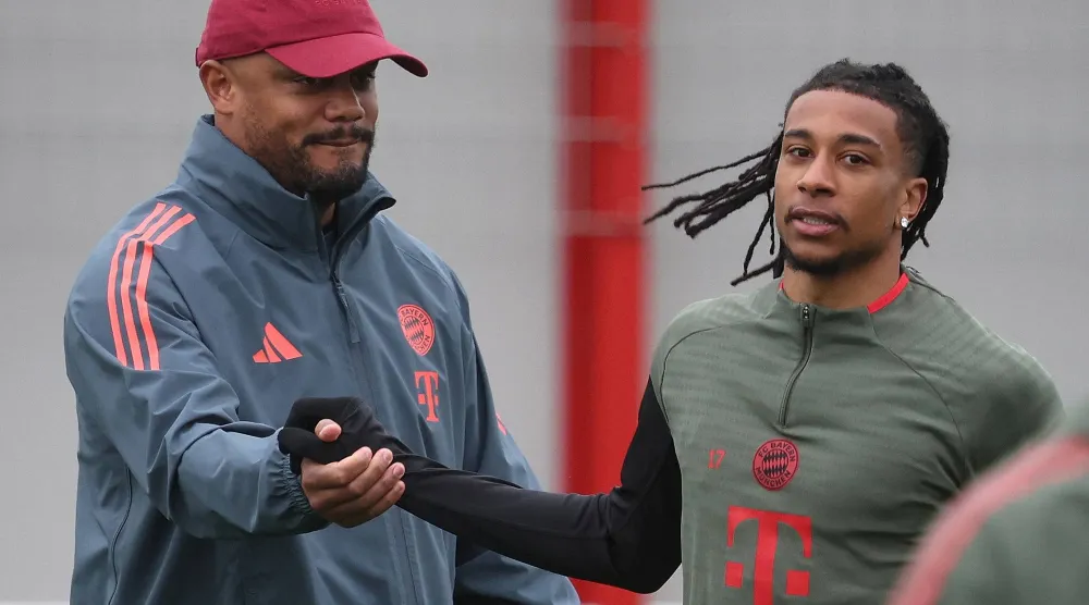 فنسن كومباني مدرب بايرن ميونيخ مع لاعبه ميكايل أوليسيه (أ.ف.ب)