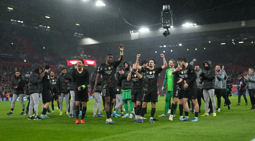 لاعبو سان جيرمان يحتفلون أمام جماهيرهم الزائرة بملعب أنفيلد (أ.ب)