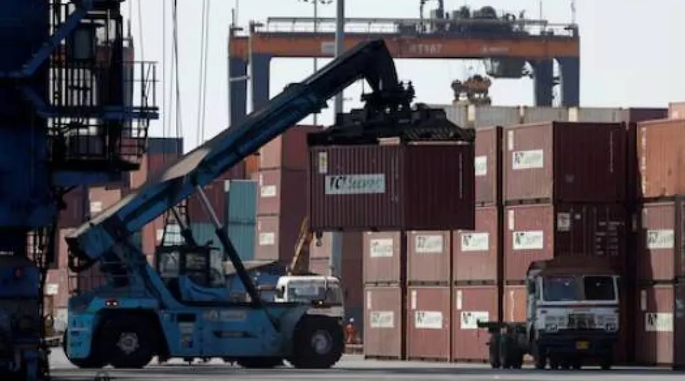 رافعة متحركة تحمل حاوية بميناء دينا دَيال في كاندلا بولاية غوجارات الغربية (رويترز)