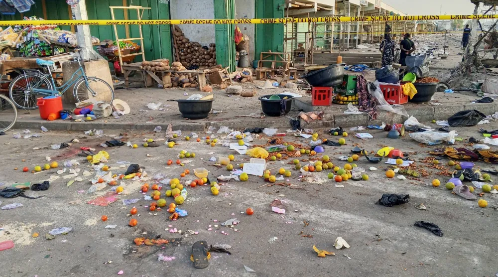 رجال شرطة وسط الأضرار التي لحقت بسوق مدينة مايدوغوري جراء التفجيرات الانتحارية (أ.ب)