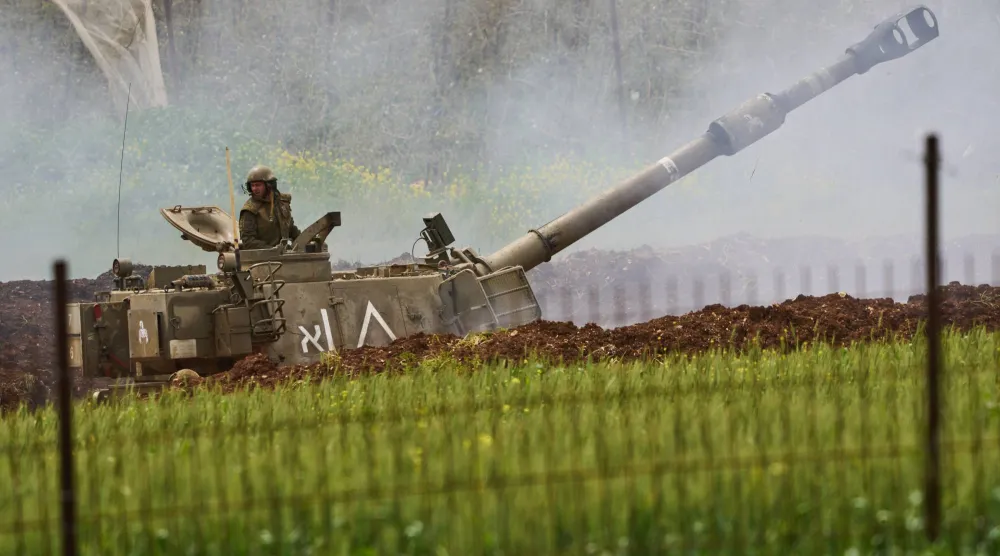 جندي إسرائيلي يقف فوق وحدة مدفعية تطلق النار باتجاه جنوب لبنان من شمال إسرائيل 15 أبريل 2026 (أ.ب)