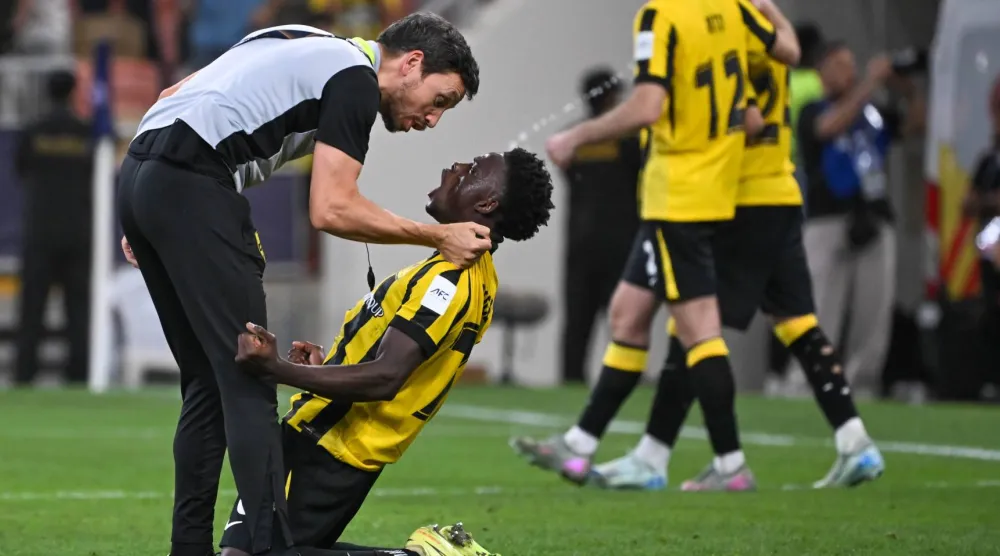 روجر فيرنانديز وفرحة جنونية مع أحد مساعدي كونسيساو بعد التأهل الآسيوي (تصوير: علي خمج)