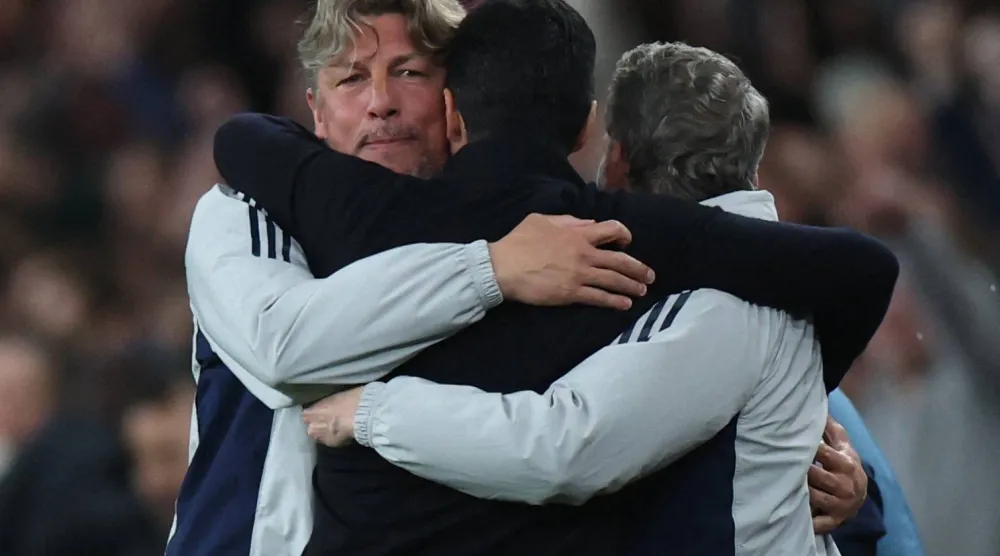 أرتيتا يحتفل مع مساعديه بعد التأهل (رويترز)