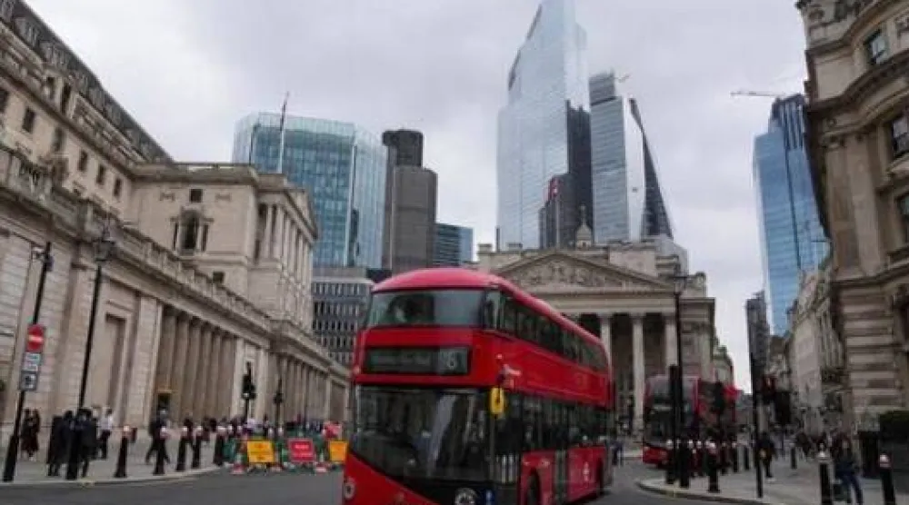 حافلات تمر أمام مبنى «بنك إنجلترا» في لندن (رويترز)