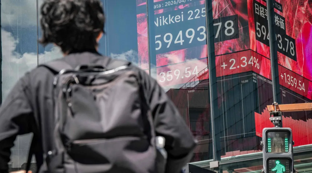 رجل ينظر إلى شاشة تعرض حركة الأسهم في وسط العاصمة اليابانية طوكيو (أ.ف.ب)