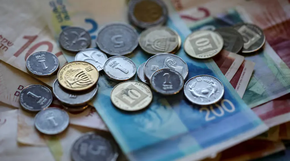 أوراق نقدية وعملات معدنية جديدة من الشيقل الإسرائيلي (رويترز)