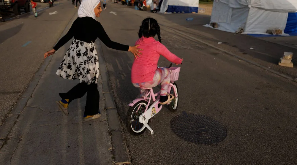 طفلتان نازحتان تلعبان بأحد مراكز النزوح في بيروت (رويترز)