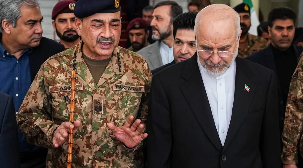 عاصم منير يتحدث إلى قاليباف على هامش لقائهما في طهران اليوم (البرلمان الإيراني)