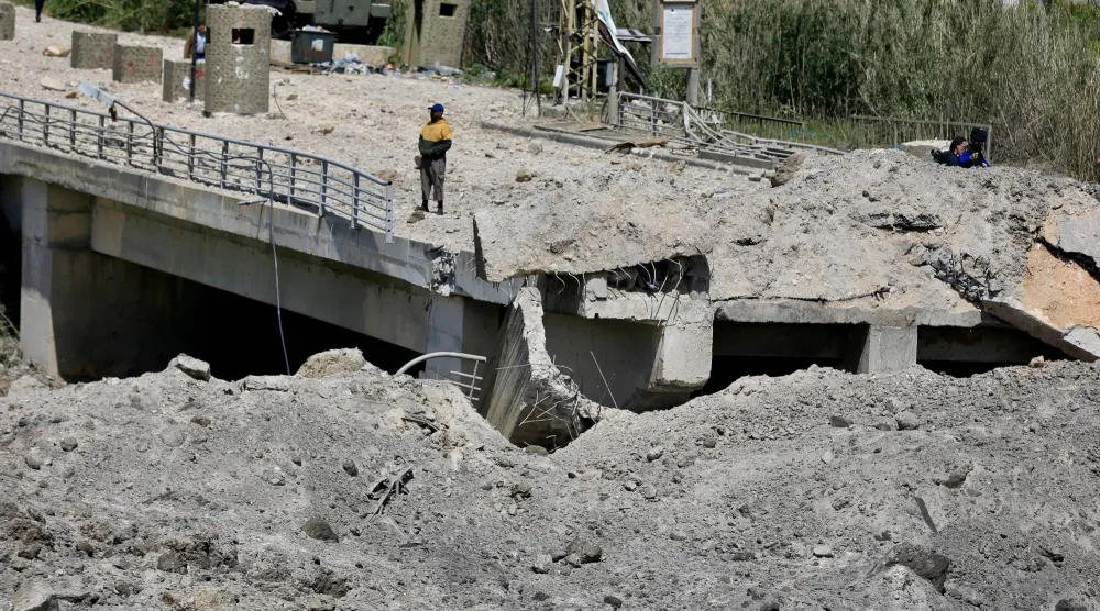 A man stands on a damaged part of the Qasmiyeh Bridge that was targeted by an Israeli airstrike near Tyre, southern Lebanon, 16 April 2026. EPA/STRINGER