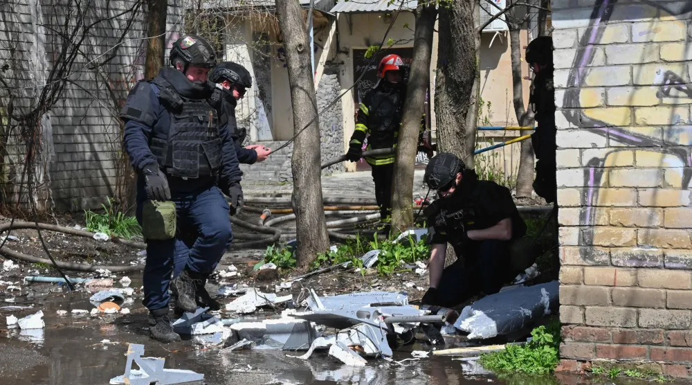 ضباط إنفاذ قانون أوكرانيون يفتشون أجزاء من طائرة مسيّرة في موقع هجوم جوي روسي على خاركيف، أوكرانيا 16 أبريل 2026 (أ.ف.ب)
