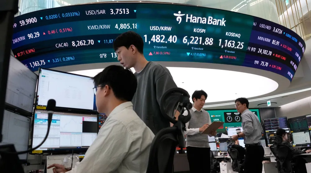 متداولون في سوق العملات يتابعون مؤشر كوسبي وسعر الدولار/الوون داخل بنك هانا في سيول (أ ب)