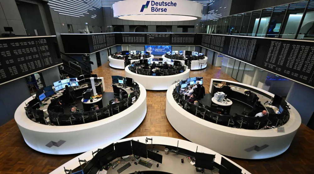 متداولون يعملون أمام شاشة تعرض مؤشر الأسهم الألماني «داكس» في بورصة فرانكفورت (أ.ف.ب)
