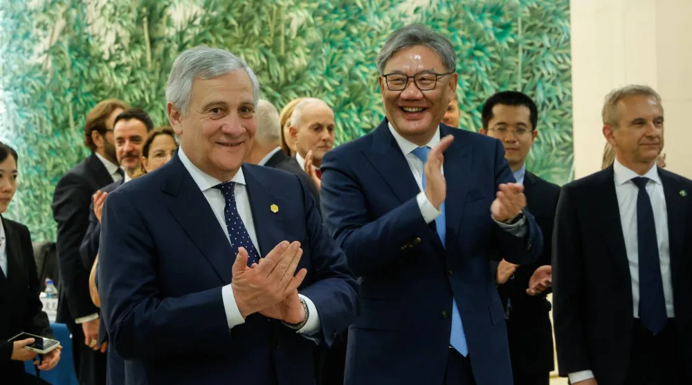 وزير الخارجية الإيطالي أنطونيو تاجاني (يسار) مع وزير التجارة الصيني وانغ وينتاو في مناسبة اقتصادية بالعاصمة الصينية بكين (إ.ب.أ)