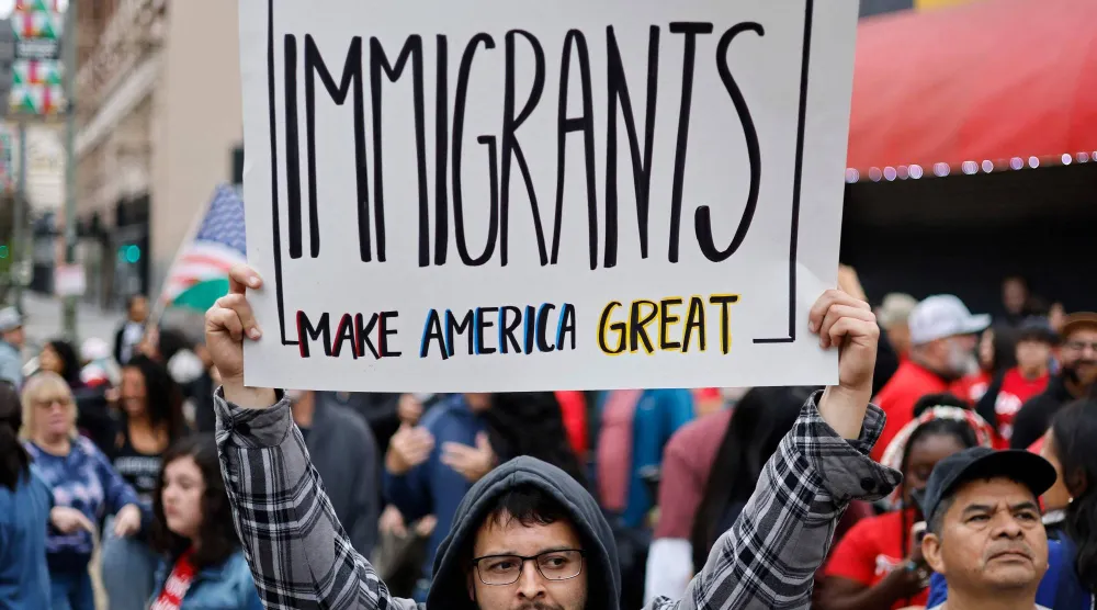 أرشيفية لأحد مؤيدي حقوق المهاجرين يحمل لافتة مكتوباً عليها «المهاجرون يجعلون أميركا عظيمة» خلال مسيرة بكاليفورنيا (أ.ف.ب)