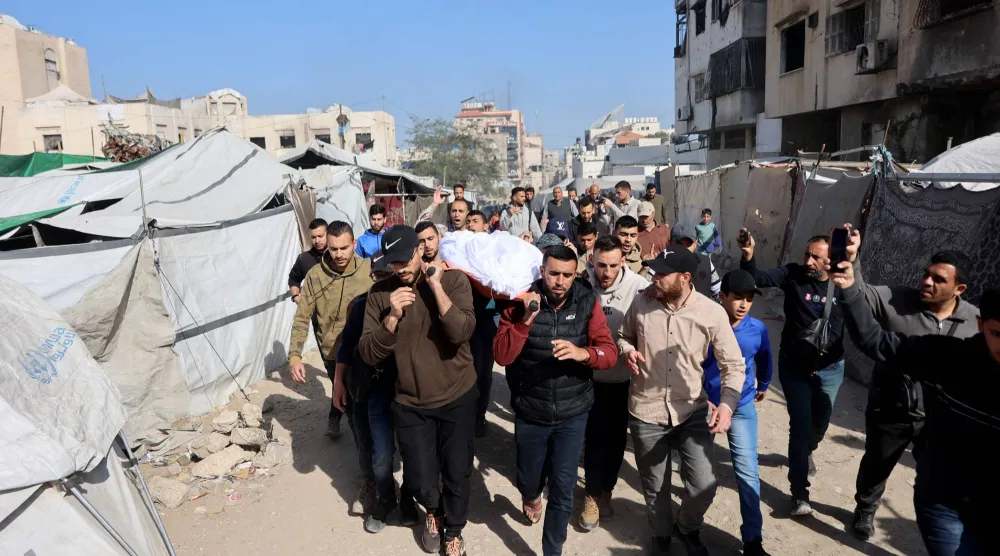 مشيعون فلسطينيون يحملون جثمان شخص قُتل في غارة إسرائيلية على مدينة غزة (أ.ف.ب)