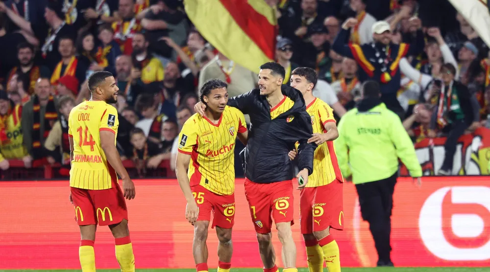 مدافع «لنس» إسماعيلو غانيو يحتفل بتسجيل هدف مع زميله المُهاجم فلوريان سوتوكا أمام «تولوز» (أ.ف.ب)